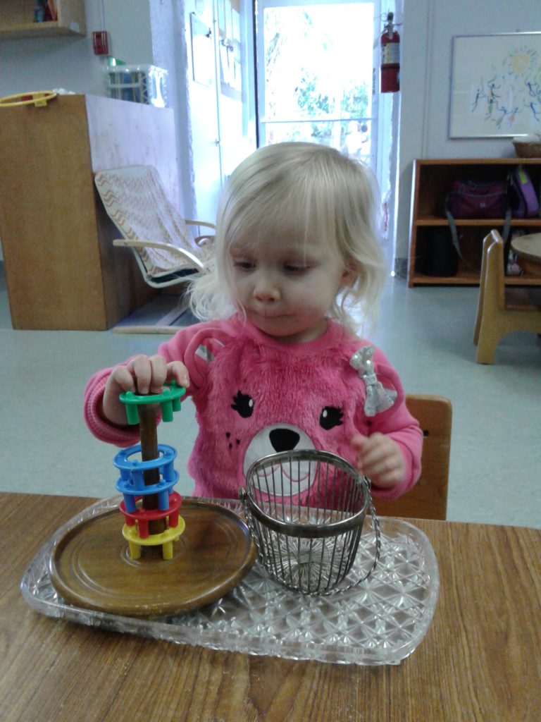 Toddler Montessori student working on a stacking activity