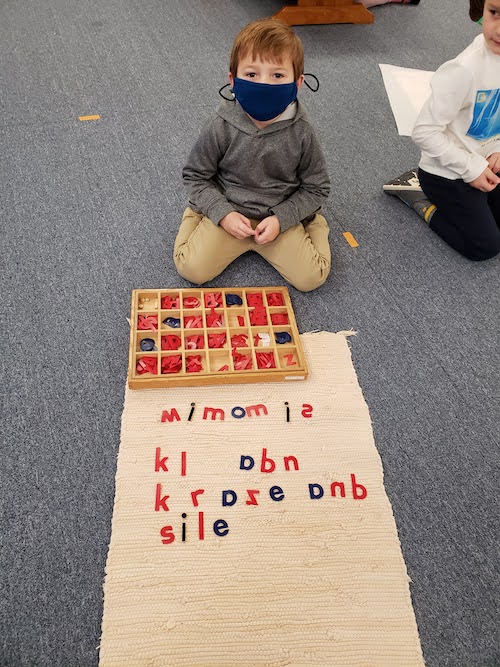 Montessori student working on a moveable alphabet activity