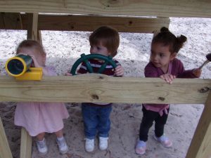 Toddler Montessori students playing on the playground at Montessori Pensacola
